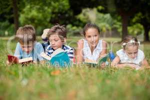 Kids lying on grass and reading books