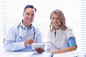 Doctor checking blood pressure of a patient in clinic