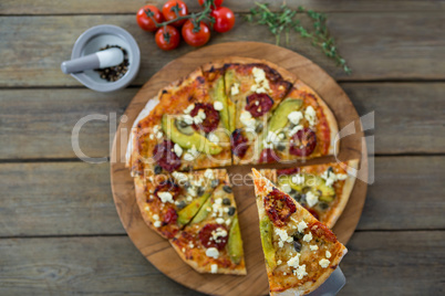 Slice of italian pizza served in a chopping board with ingredients