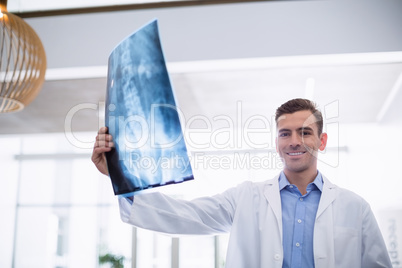 Doctor standing with x-ray in corridor