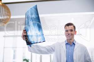 Doctor standing with x-ray in corridor