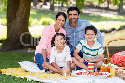 Happy family having breakfast in park