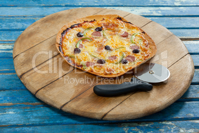 Delicious pizza served on pizza tray with cutter