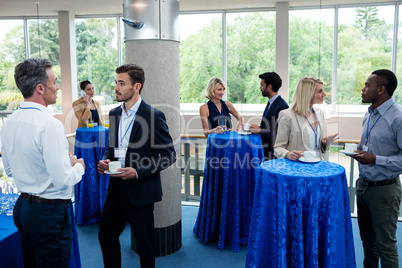 Business executives interacting with each other while having coffee