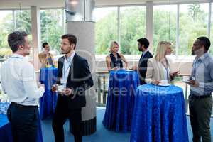 Business executives interacting with each other while having coffee