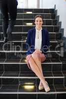 Happy businesswoman sitting on steps