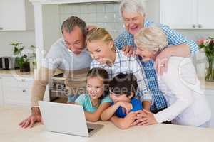 Family using laptop in kitchen