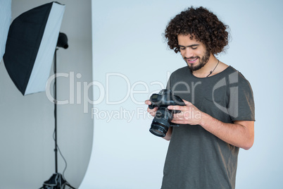 Photographer looking at captured photos in his digital camera
