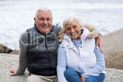 Senior couple sitting on rock at beach