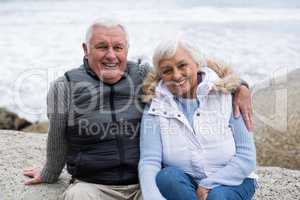 Senior couple sitting on rock at beach