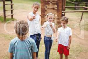 Upset boy with friends gossiping in background