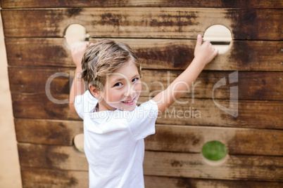 Boy climbing on a playground ride in park