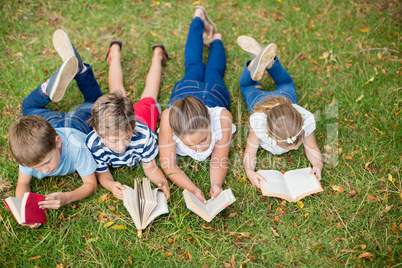 Kids lying on grass and reading books