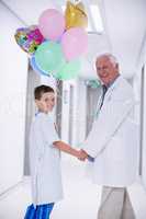 Doctor walking with patient in hospital corridor