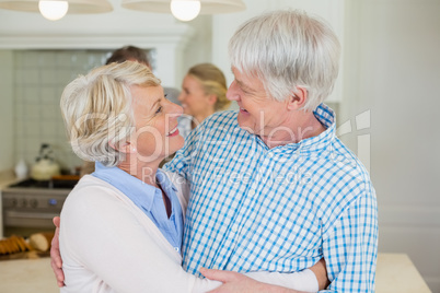 Romantic senior couple looking face to face in kitchen