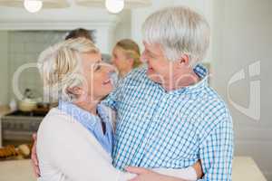 Romantic senior couple looking face to face in kitchen