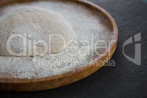 Pizza dough ball on a wooden tray