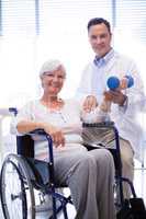 Portrait of physiotherapist assisting senior patient with hand exercise