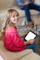 Girl using digital tablet in living room