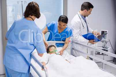 Doctors examining patient in ward