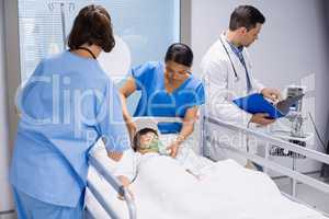 Doctors examining patient in ward