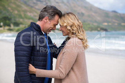 Mature couple standing face to face on the beach