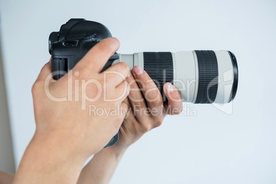 Close-up of photographer holding digital camera