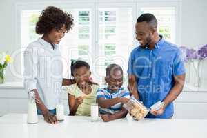 Father giving cookies to kids