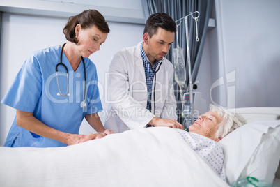 Doctors examining senior patient with stethoscope