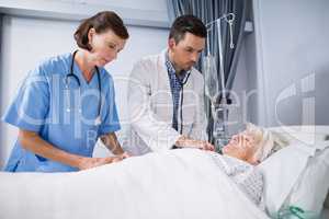 Doctors examining senior patient with stethoscope