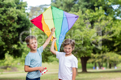 Two boys holding a kite in park