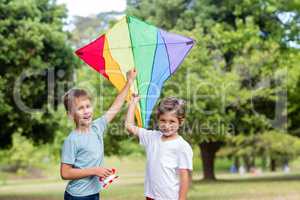 Two boys holding a kite in park