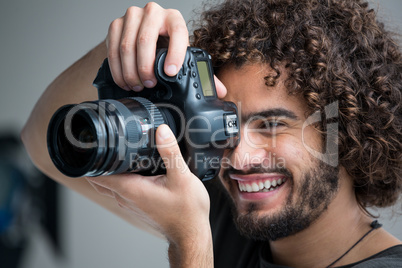 Male photographer with digital camera in studio