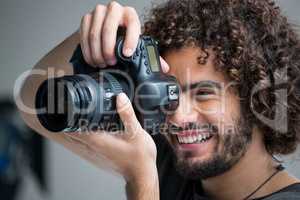 Male photographer with digital camera in studio