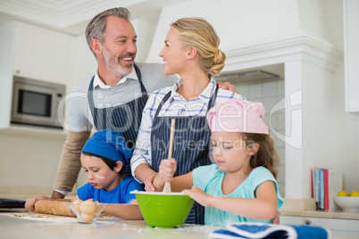 Parents and kids preparing food in kitchen