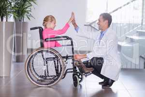Doctor giving high five to disable girl
