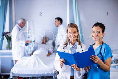 Portrait of two female doctors checking the medical report of a patient