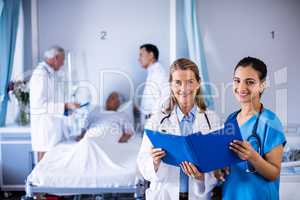Portrait of two female doctors checking the medical report of a patient