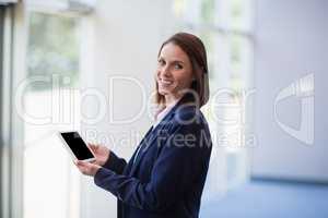 Cheerful businesswoman holding a digital tablet