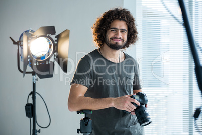 Happy male photographer standing in studio