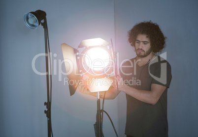 Male photographer adjusting spotlight