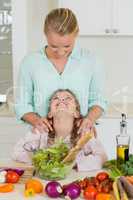 Smiling daughter interacting with mother in kitchen