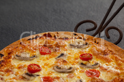 Delicious pizza served on pizza tray with cutter on wooden plank