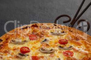 Delicious pizza served on pizza tray with cutter on wooden plank