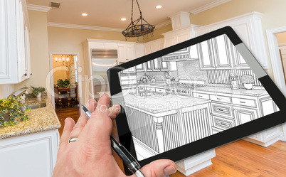 Hand on Computer Tablet Showing Drawing of Kitchen Photo Behind.