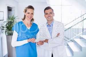 Portrait of smiling nurse and doctor using over digital tablet