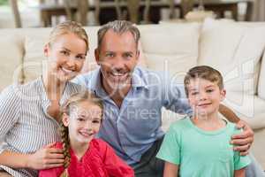 Portrait of happy parents and kids sitting on sofa in living room