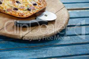 Italian pizza served on pizza tray with cutter