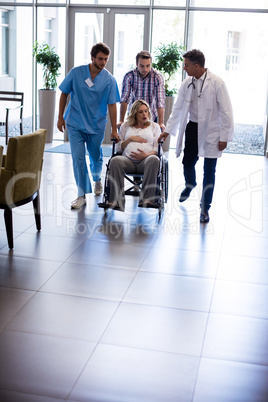 Male doctor talking to pregnant woman in wheelchair