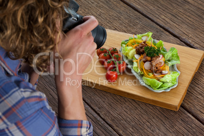 Photographer clicking a picture of food using digital camera